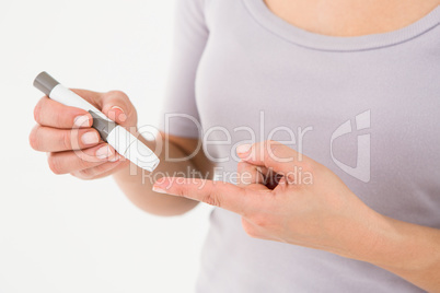 Diabetic woman using blood glucose monitor