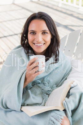 Pretty brunette sitting on a chair and drinking coffee