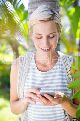 Pretty blonde woman texting with her mobile phone