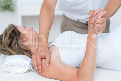Doctor bending his patient arm