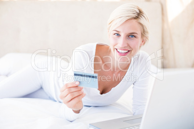 Smiling blonde woman doing online shopping