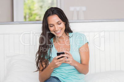 Happy brunette using her phone