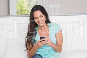 Happy brunette using her phone