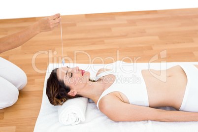 Woman being hypnotized while lying on the floor