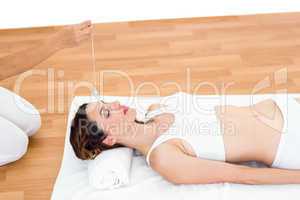 Woman being hypnotized while lying on the floor
