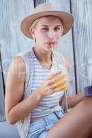 Pretty blonde woman using her tablet and drinking orange juice