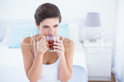 Thoughtful  woman drinking cup of tea