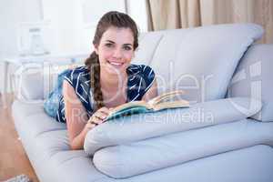 Happy brunette reading a book