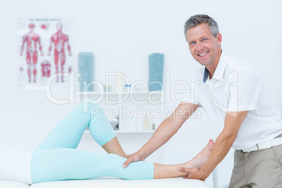 Physiotherapist doing leg massage to his patient