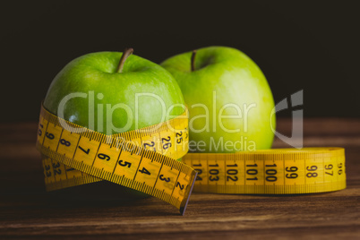 Green apples with measuring tape