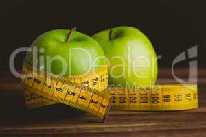 Green apples with measuring tape