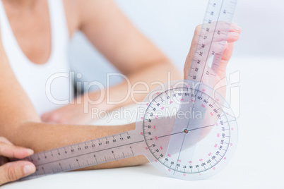 Doctor measuring wrist with goniometer