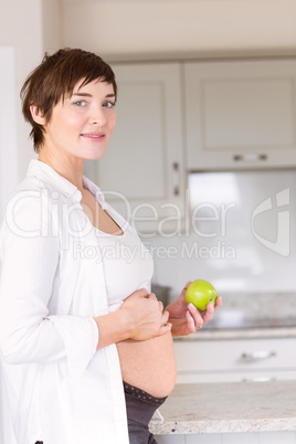 Pregnant woman holding an apple