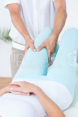 Physiotherapist doing leg massage to his patient