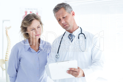 Doctor showing his notes to his patient