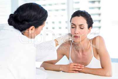 Doctor examining her patients neck