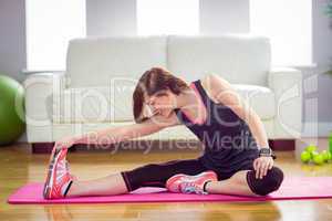 Fit woman stretching on exercise mat