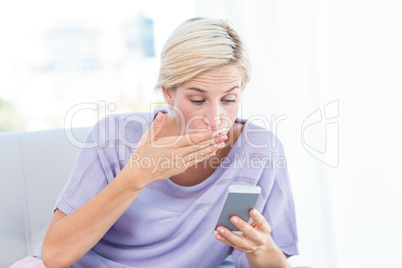 Pretty blonde woman texting with her mobile phone