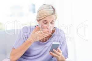 Pretty blonde woman texting with her mobile phone