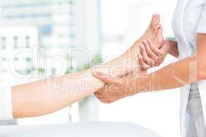 Physiotherapist massaging her patients foot