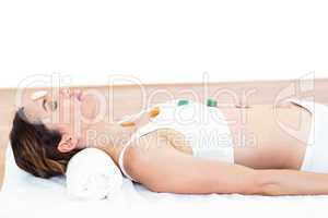 Relaxed brunette lying on mat with stones