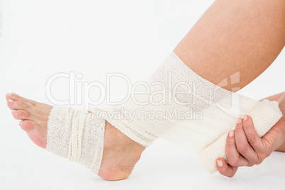 Sitting woman banding her ankle