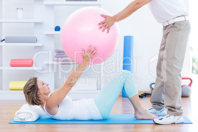 Therapist helping his patient with exercise ball Therapist helping his patient with exercise ball