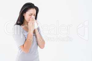 Sick brunette blowing her nose