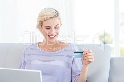 Pretty blonde woman doing online shopping