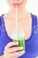 Attractive woman drinking green juice