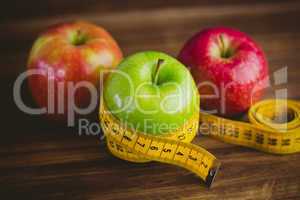 Green and red apples with measuring tape