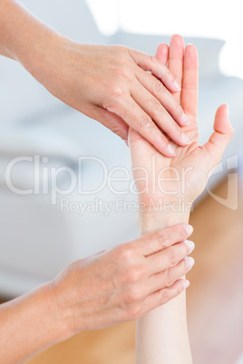 Physiotherapist examining her patients hand