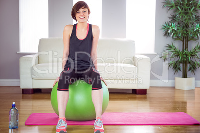 Fit woman sitting on exercise ball