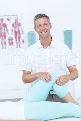 Physiotherapist doing leg massage to his patient