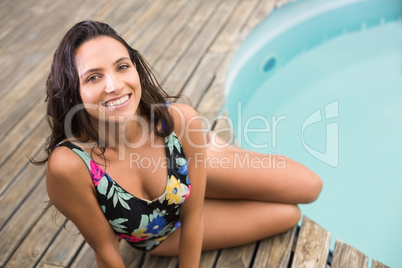 Happy brunette sitting in swimwear