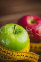 Green and red apples with measuring tape