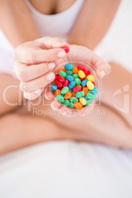Woman holding candies on bed