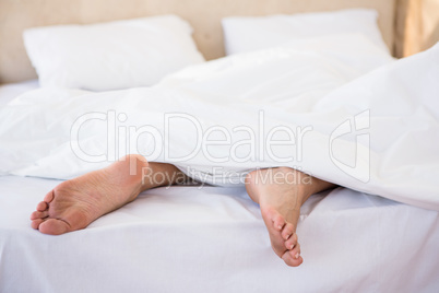 Woman feet under a duvet