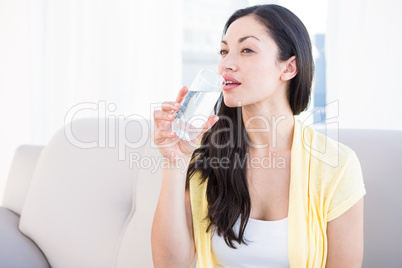 Pretty brunette drinking glass of water