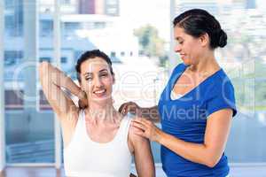 Woman stretching her arm with her therapist