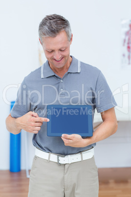 Smiling doctor showing digital tablet