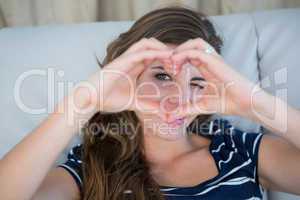 Smiling brunette making heart with her hands