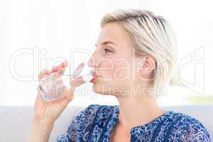 Pretty blonde woman drinking glass of water
