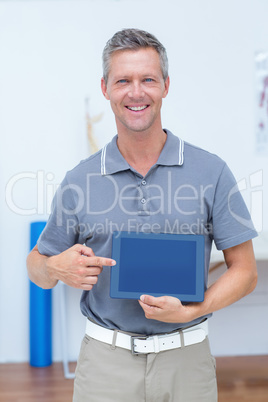 Smiling doctor showing digital tablet