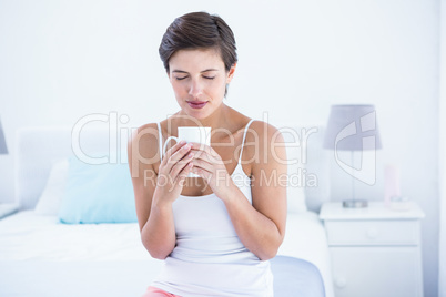 Attractive brunette drinking cup of coffee