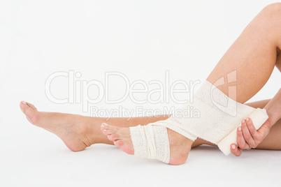 Sitting woman banding her ankle