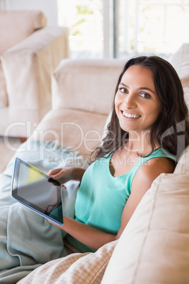 Pretty brunette using tablet pc on the couch