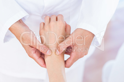 Doctor examining her patients wrist