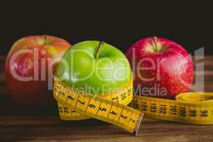 Green and red apples with measuring tape