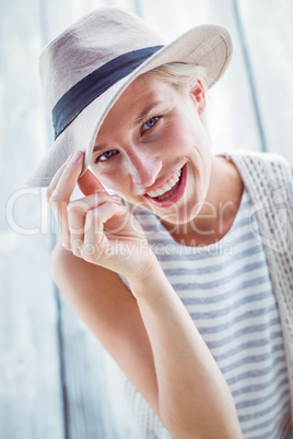 Pretty blonde woman wearing hat and smiling at camera